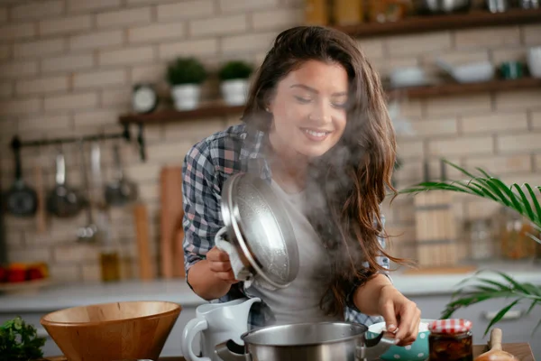 Young Woman Cooking in the kitchen. Woman cooking pasta dish.