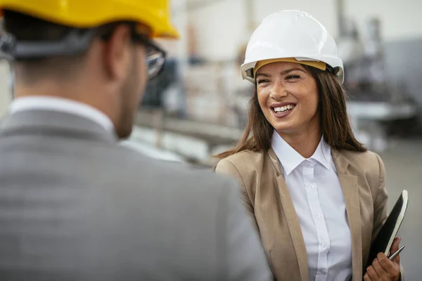 İşadamı ve işkadını fabrikadaki yeni iş projesini tartışıyor
