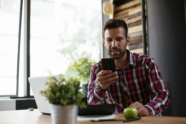 Ofisteki işadamı telefonu kullanıyor. Ofiste çalışan genç bir işadamı..