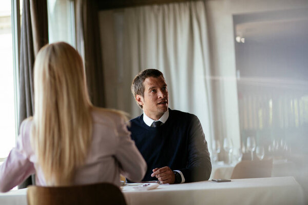 Красивый бизнесмен пьет вино. Бизнесмен наслаждается в ресторане