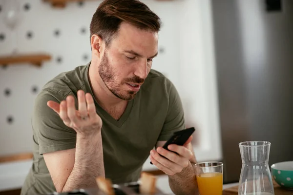 Junger Mann Frühstückt Und Liest Die Nachrichten Online Schöner Mann Stockfoto