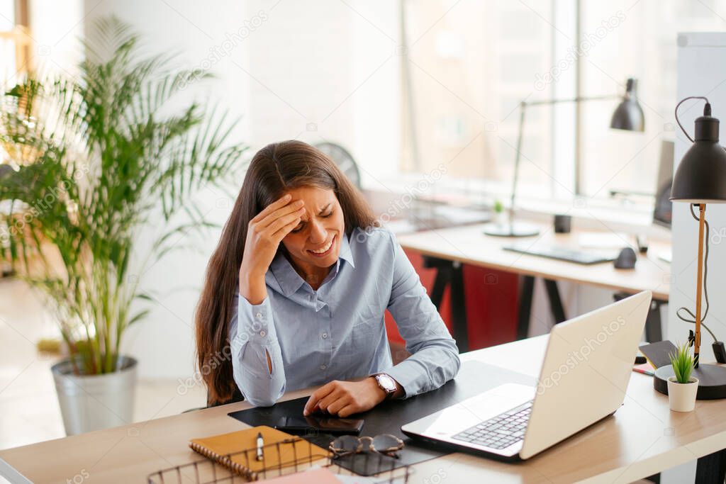 Exhausted businesswoman sitting and working in office