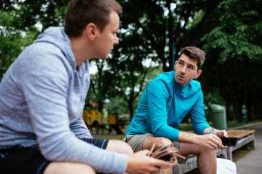 Koşmaktan istirahat eden zinde genç adamlar. Dışarıda antrenman yapan iki arkadaş..