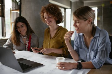 İş kadınları yeni bir proje üzerinde çalışıyor. İş arkadaşları ofiste iş tartışıyor.
