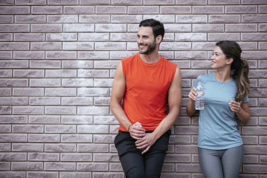 Atletik çift şehirde koştuktan sonra dinleniyor. Mutlu çift sabahları eğleniyor...