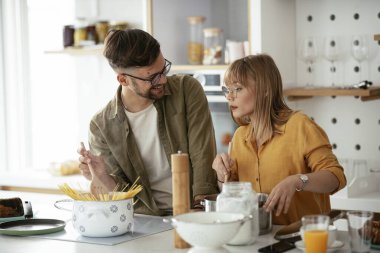Karı koca mutfakta. Genç çift evde lezzetli yemekler hazırlıyor..