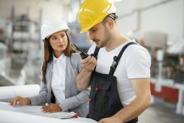 Fabrika işçisi ve mühendis teftiş yapıyor. Fabrika işçisi ve işkadını üretim hattında..