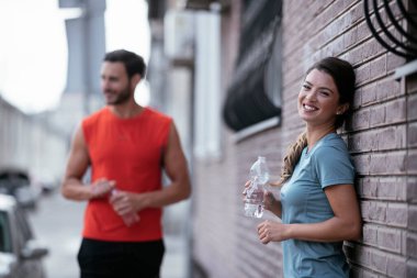 Atletik çift şehirde koştuktan sonra dinleniyor. Mutlu çift sabahları eğleniyor...