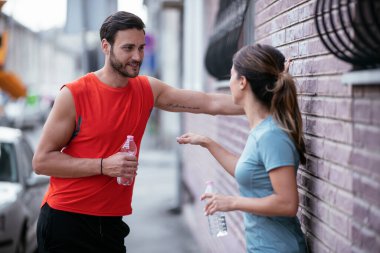 Atletik çift şehirde koştuktan sonra dinleniyor. Mutlu çift sabahları eğleniyor...