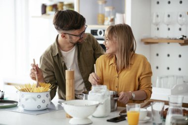 Karı koca mutfakta. Genç çift evde lezzetli yemekler hazırlıyor..