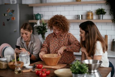 Kadın arkadaşlar mutfakta eğleniyor. Kardeşler birlikte yemek pişirir..