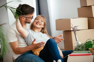 Karı koca daireye taşınıyorlar. Mutlu çift eşyalarını boşaltıyor.