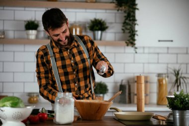 Mutfaktaki yakışıklı adamın portresi. Genç adam lezzetli yemekler hazırlıyor..