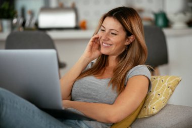 Güzel bir kadın görüntülü görüşme yapıyor. Genç mutlu kadın evde eğleniyor..