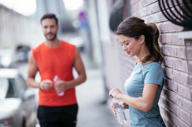 Atletik çift şehirde koştuktan sonra dinleniyor. Mutlu çift sabahları eğleniyor...
