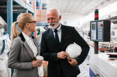 Erkek ve kadın iş tartışıyorlar. Fabrikada çalışan meslektaşlar.