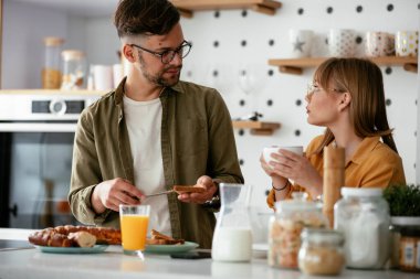 Genç çift evde lezzetli yemekler yapıyor. Sevgi dolu çift mutfakta eğleniyor..