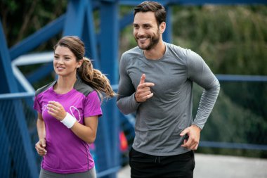 Atletik çift şehirde koşuyor. Mutlu çift dışarıda antrenman yapıyor..
