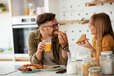 Genç çift evde lezzetli yemekler yapıyor. Sevgi dolu çift mutfakta eğleniyor..