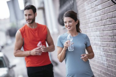 Atletik çift şehirde koştuktan sonra dinleniyor. Mutlu çift sabahları eğleniyor...