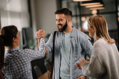 Modern açık uzay ofisinde sıradan iş adamlarından oluşan bir grup. İş kadınları ve işadamları yeni proje hakkında konuşuyor.