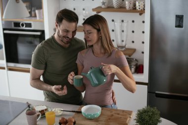 Mutlu çift mutfakta kahvaltı yapıyor. 