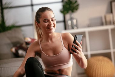 Evde egzersiz yapan genç bir kadın.