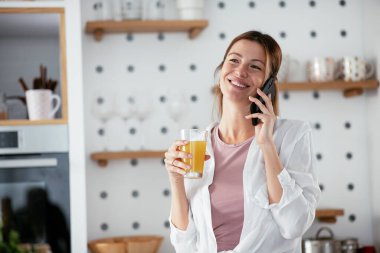 Mutfaktaki kadın. Mutfakta telefon kullanan güzel bir kadın..