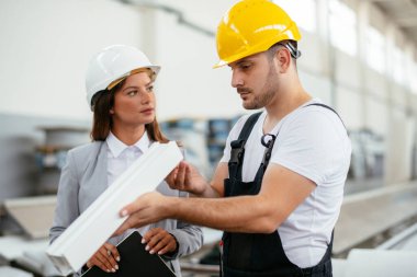 Fabrika işçisi üretim hattında müdürüyle konuşuyor.