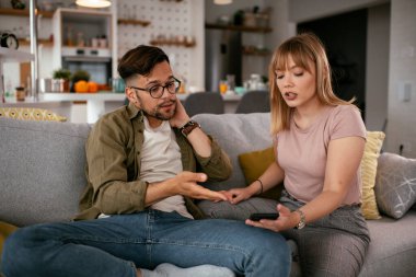 Erkek arkadaşı ve kız arkadaşı kanepede tartışıyor. Kızgın kadın erkek arkadaşına bağırıyor..