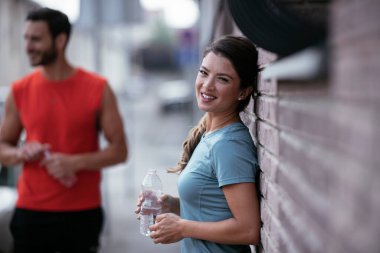 Atletik çift şehirde koştuktan sonra dinleniyor. Mutlu çift sabahları eğleniyor...