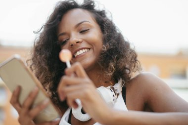 Güzel Afrikalı kadın açık havada telefon kullanıyor.