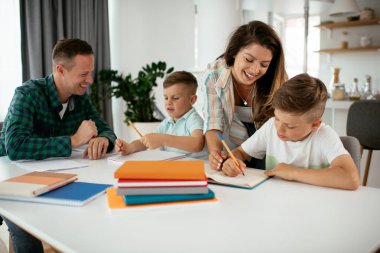 Ebeveynler çocuklara ev ödevlerinde yardım ediyorlar. Küçük çocuklar evde öğreniyor..