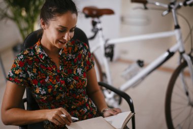 Genç ve güzel bayan girişimci iş yerinde not alıyor. 