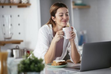 Güzel bir kadın görüntülü görüşme yapıyor. Güzel kadın evde eğleniyor..
