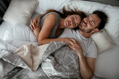 Yatakta genç bir çift. Mutlu çift yatakta dinleniyor..