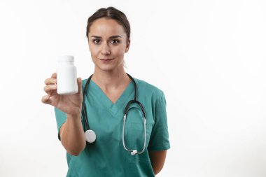 Genç kadın doktorun portresi beyaza izole edilmiş kameraya bakıyor