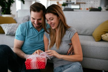 Koca, karısına hediyeyle sürpriz yapıyor. Genç adam karısına hediye kutusu veriyor..