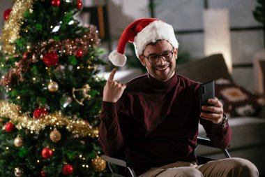 Yılbaşı ağacının yanında görüntülü görüşme yapan engelli bir adam