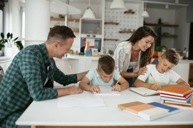 Ebeveynler çocuklara ev ödevlerinde yardım ediyorlar. Küçük çocuklar evde öğreniyor..