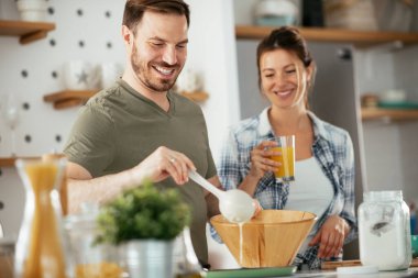 Genç çift evde krep yapıyor. Sevgili çift yemek yaparken eğleniyor..