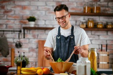 Mutfakta makarna hazırlayan yakışıklı adam. Lezzetli yemek pişiren adam..