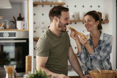 Genç çift evde krep yapıyor. Sevgili çift yemek yaparken eğleniyor..