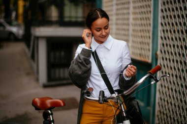 Sokakta müzik dinleyen genç bir kadın..