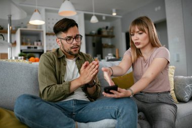 Erkek arkadaşı ve kız arkadaşı kanepede tartışıyor. Kızgın kadın erkek arkadaşına bağırıyor..