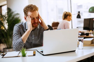 İşyerinde çalışan kızıl saçlı bir iş adamı.