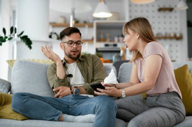 Karı koca kanepede tartışıyor. Kızgın eş kocasına bağırıyor.