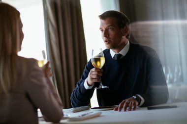 Şarap içen yakışıklı bir iş adamı. İş adamı restoranda eğleniyor.