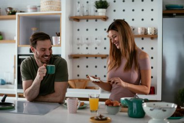 Mutlu çift mutfakta kahvaltı yapıyor. 