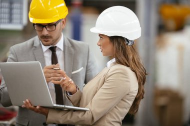 Fabrika müdürü ve mühendisi teftiş yapıyor. İş adamı ve işkadını üretim hattında.